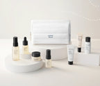 A skincare product set from Aesop's Expert Ritual collection, featuring a white zippered pouch and multiple bottles, jars, and tubes arranged on minimalist white pedestals against a clean white background.