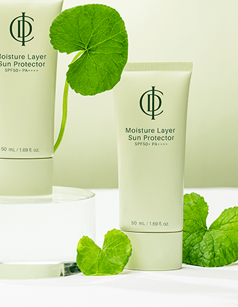 Moisture Layer Sun Protector cream with green leaves on a white background