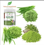 A white plastic jar labeled 'Natural Superfoods ALKALINE GREENS' surrounded by green chives, green powder, and microgreens on a white background.
